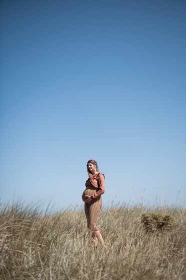 Schwangere Frau trägt Strickrock von Karin Fraidenraij und Bluse mit Rüschen von Lanius