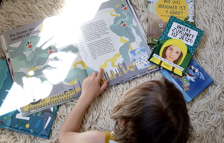 Kinderbücher zum Thema Umweltschutz Kind liegt auf Teppich mit Büchern